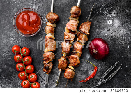 Kebabs grilled meat skewers, shish kebab, on black dark stone table background, top view flat lay 83884700