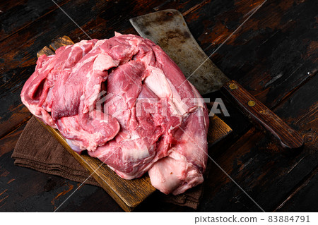 Raw lamb shoulder meat ready for baking, on old dark wooden table background 83884791