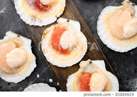 Frozen sea Scallops, on black dark stone table background, top view flat lay 83884829