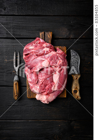 Fresh raw mutton shoulder meat, on black wooden table background, top view flat lay, with copy space for text 83884855
