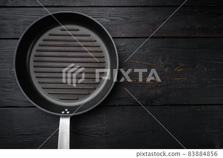 Vintage empty grill pan with copy space for text or food with copy space for text or food, top view flat lay , on black wooden table background Vintage empty grill pan with copy space for text or food with copy space for text or food, top view flat lay , on black wooden table background 83884856