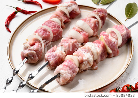 Shish kebab pork meat skewers or shashlik, on white stone table background Shish kebab pork meat skewers or shashlik, on white stone table background 83884858
