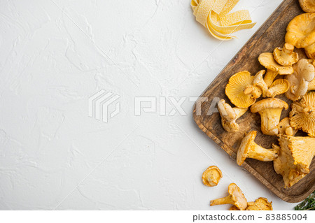 Raw pasta and mushrooms and ingredients, on white stone table background, top view flat lay, with copy space for text 83885004