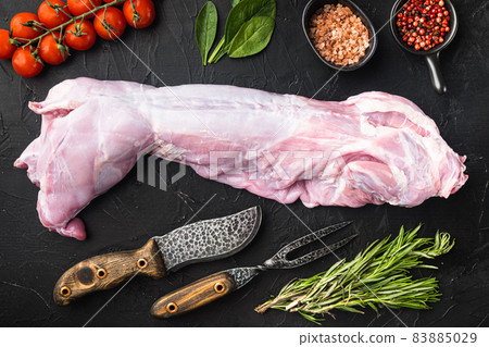 Raw and fresh meat. Whole rabbit ready to cook with ingredients, on black stone background, top view flat lay 83885029