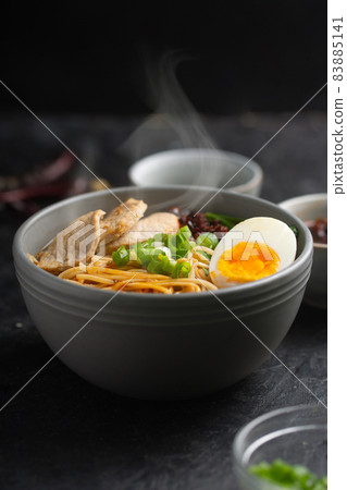 Ramen is asian noodles in a bowl with meat and vegetables or seafood 83885141