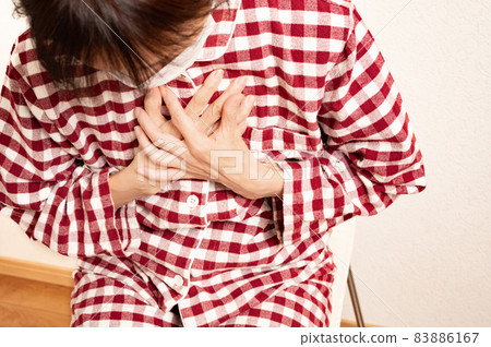 A middle-aged woman who has a pain in her chest 83886167