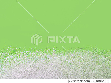 Calorie-free sweetener powder scattered on green background Calorie-free sweetener powder scattered on green background 83886450