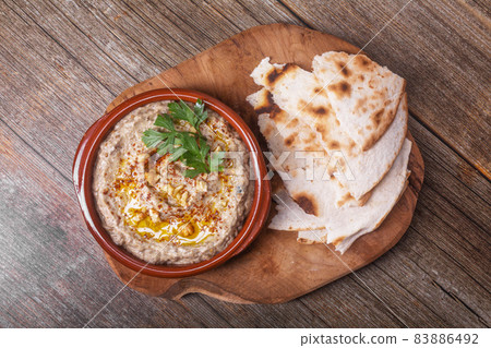 Esme, baba ganush from baked eggplant with sesame paste and pieces of lavash with walnuts on a wooden board Esme, baba ganush from baked eggplant with sesame paste and pieces of lavash with walnuts on a wooden board 83886492