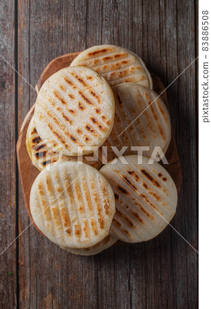 Traditional Venezuelan food arepa made from cornmeal, wooden background 83886508
