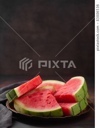 Red raw watermelon pieces on dark background 83886536