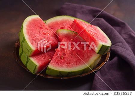 Red raw watermelon pieces on dark background Red raw watermelon pieces on dark background 83886537