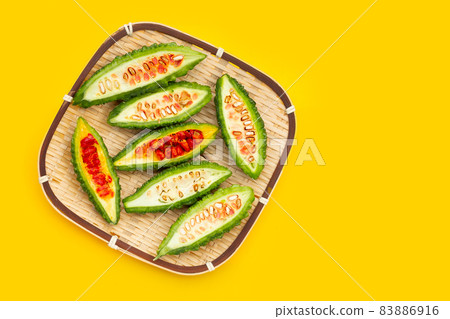 Bitter gourd in bamboo basket on yellow background. 83886916