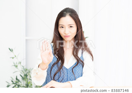 Housewife sitting on a chair in the living room posing NG 83887146