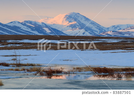 Scenic landscape with spring tundra and mountains at sunset. Scenic landscape with spring tundra and mountains at sunset. 83887501