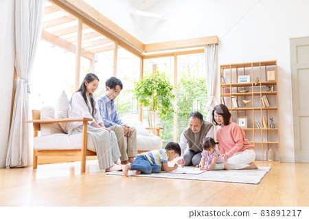 Three-generation family relaxing in the living room 83891217