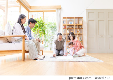 Three-generation family relaxing in the living room 83891328