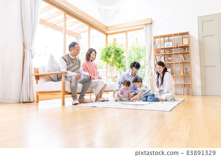 Three-generation family relaxing in the living room 83891329