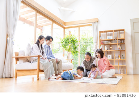 Three-generation family relaxing in the living room 83891430