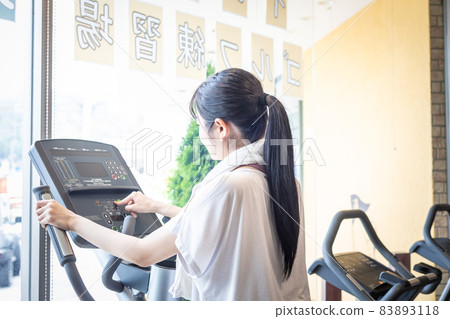 Female operating the panel of a walking machine Female operating the panel of a walking machine 83893118