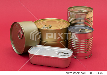 Unopened Tin Cans with Blank Edges on Red Background Unopened Tin Cans with Blank Edges on Red Background 83893363