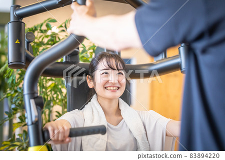 Female under the guidance of a personal trainer 83894220
