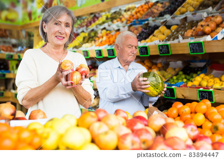 Married couple buy ripe apples and watermelon in supermarket Married couple buy ripe apples and watermelon in supermarket 83894447