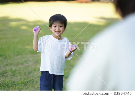 Parents and children playing with water balloons Parents and children playing with water balloons 83894743