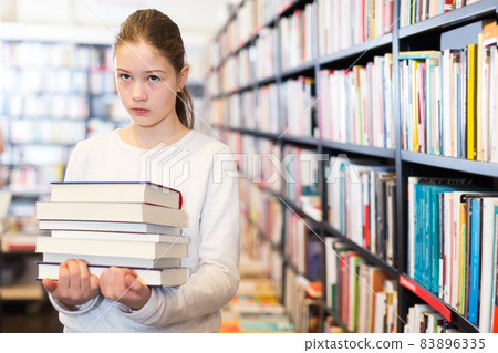 schoolgirl with pile of textbooks schoolgirl with pile of textbooks 83896335