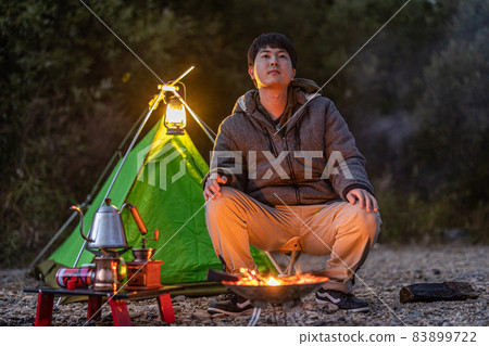 Enjoy a bonfire at a solo camp 83899722