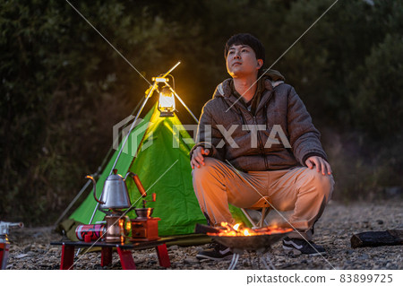 Enjoy a bonfire at a solo camp 83899725