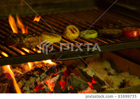 grilled meat and vegetables baked on a grid on an open fire 83899735