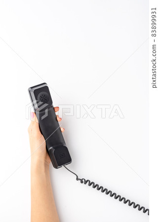 Overhead shot of female hand holding vintage phone isolated on white background. Customer support concept 83899931