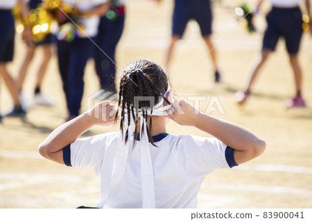 Girl tightening a headband at an athletic meet 83900041