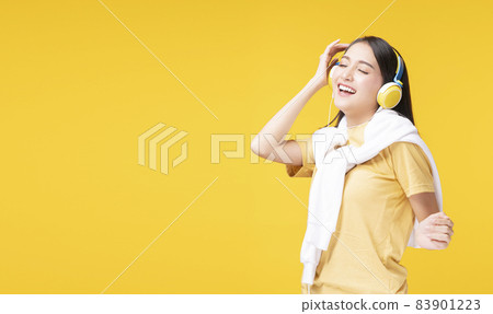 Cheerful enjoy young woman wearing headphones listening to music form smartphone and dancing relax  83901223