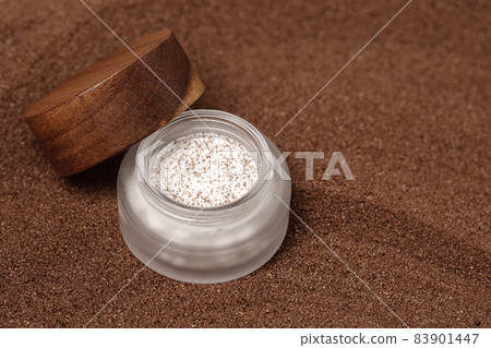 Homemade scrub with brown sugar and coffee in glass jar with wooden lid on brown sand background. Beauty, Spa, skin care, aromatherapy, eco friendly concept. Homemade scrub with brown sugar and coffee in glass jar with wooden lid on brown sand background. Beauty, Spa, skin care, aromatherapy, eco friendly concept. 83901447