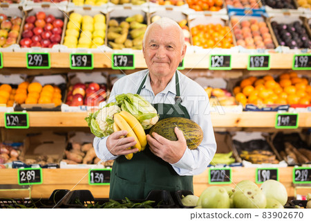 Old man green grocer worker standing in salesroom Old man green grocer worker standing in salesroom 83902670