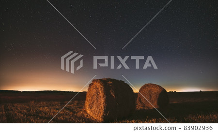 Comet Neowise C 2020 F3 In Night Starry Sky Above Haystacks In Summer Agricultural Field. Night Stars Above Rural Landscape With Hay Bales After Harvest. Agricultural Concept. 4K Timelapse 83902936