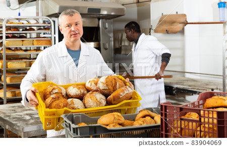 Bakery worker carrying box with loaves Bakery worker carrying box with loaves 83904069