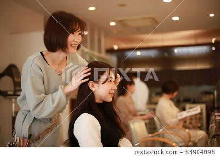 Image of a hairdresser who cuts hair 83904098