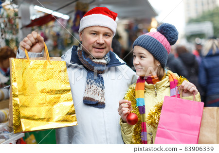 Smiling girl and father with shopping bags Smiling girl and father with shopping bags 83906339