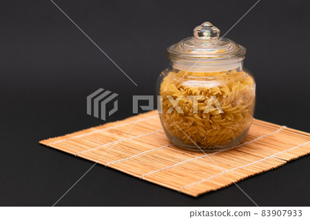 Uncooked Fusilli Pasta in Glass Jar 83907933