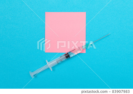 Vaccination or Revaccination Concept - A Medical Syringe on Blue Table 83907983