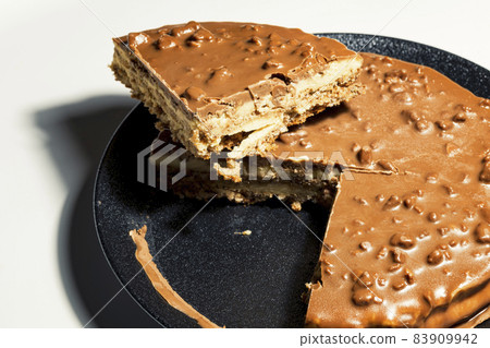Swedish almond and chocolate cake with a slice cut off, with filling and nuts Swedish almond and chocolate cake with a slice cut off, with filling and nuts 83909942