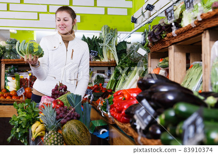 Young woman in greengrocery Young woman in greengrocery 83910374