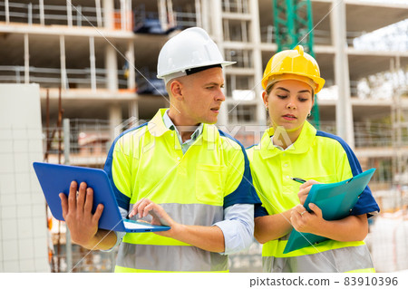 Two architects with laptop discussing construction plan 83910396
