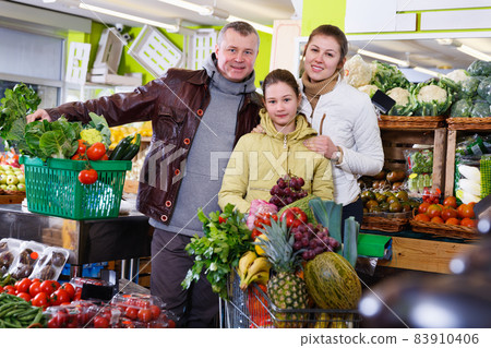 Family with shopping cart full of fruits and vegetables 83910406