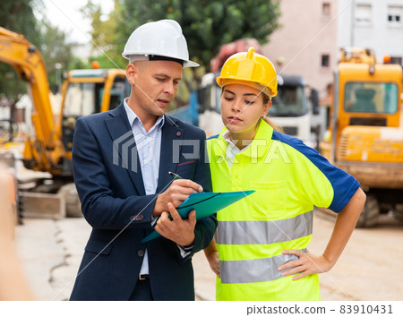 Man and woman engineers in construction site Man and woman engineers in construction site 83910431