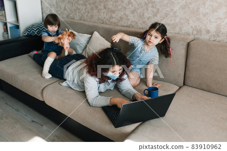two little girls sit on their mother's back while working on the computer two little girls sit on their mother's back while working on the computer 83910962