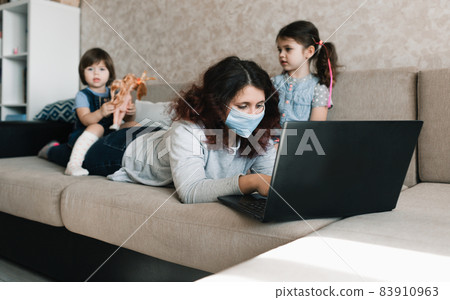 two little girls sit on their mother's back while working on the computer two little girls sit on their mother's back while working on the computer 83910963