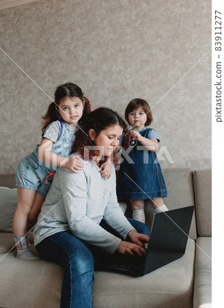 small children prevent their mother from working on the computer small children prevent their mother from working on the computer 83911277